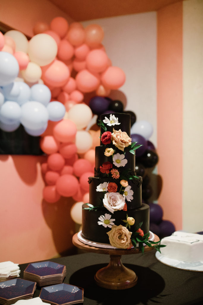 large black cake with blooms from dallas area cake artist