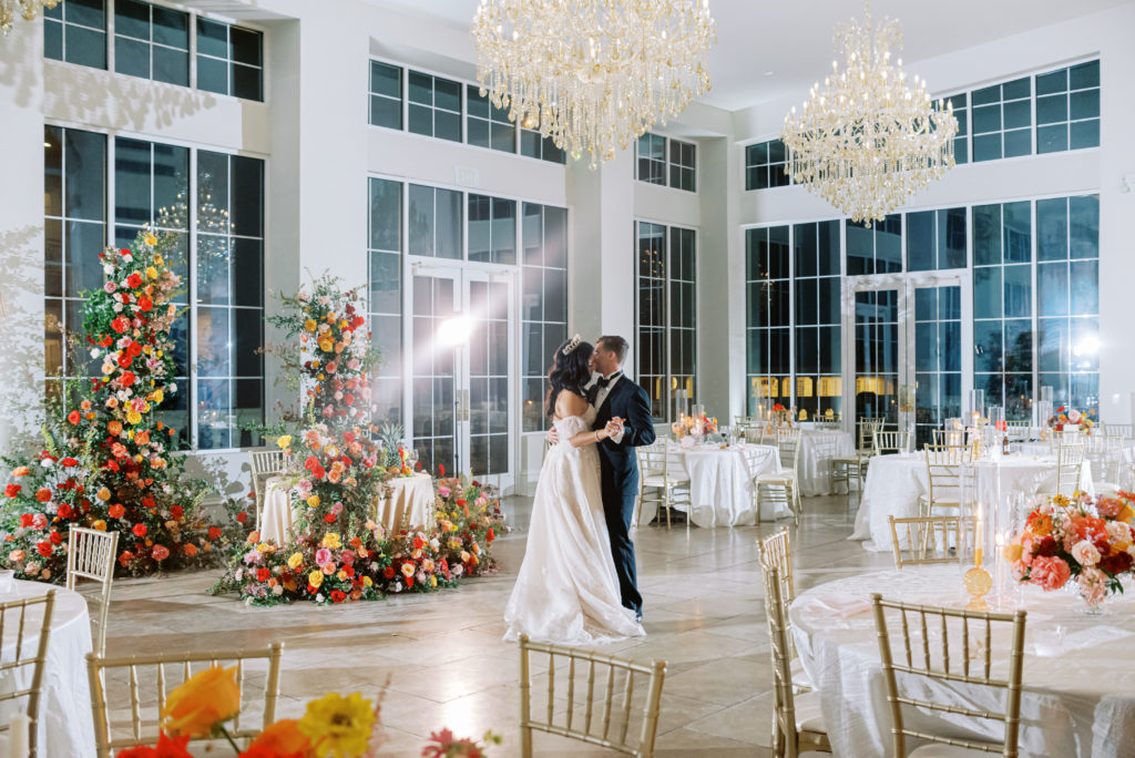 Couple dancing in ballroom, with floral designed by The Floral Eclectic. Photo taken by Neva Michelle Photography.